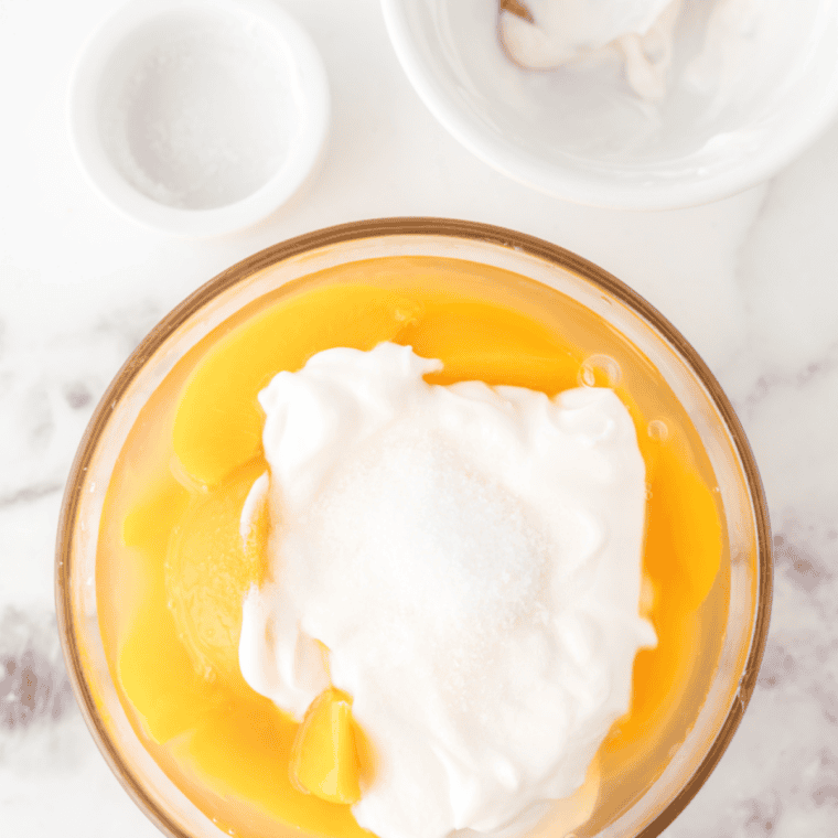 Peach ice cream mixture poured into a Ninja Creami pint container, ready to freeze for 24 hours.