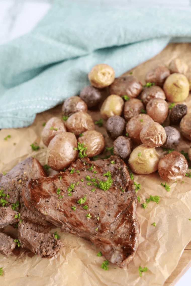 Cooked Blackstone sirloin steaks resting on a wooden cutting board before being sliced against the grain.