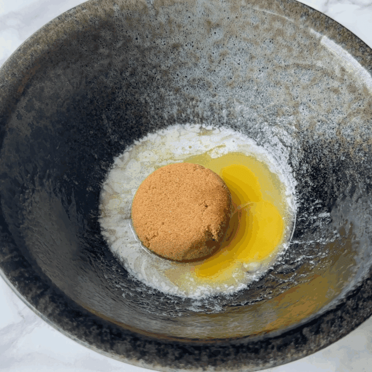 Mixing butter, sugars, egg, and vanilla in a small bowl