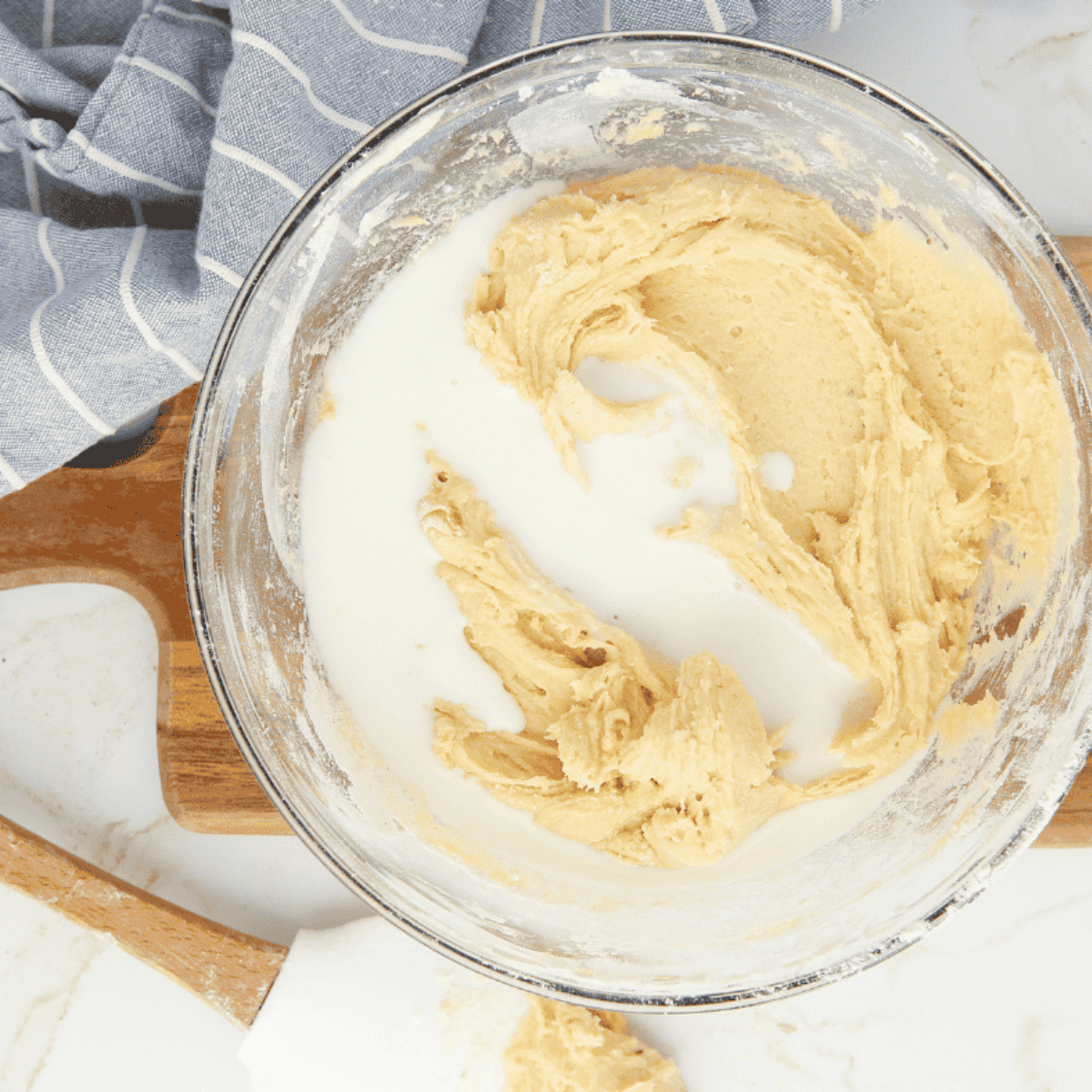 Mixing cake batter by combining dry ingredients and creaming butter, sugars, eggs, vanilla, and milk