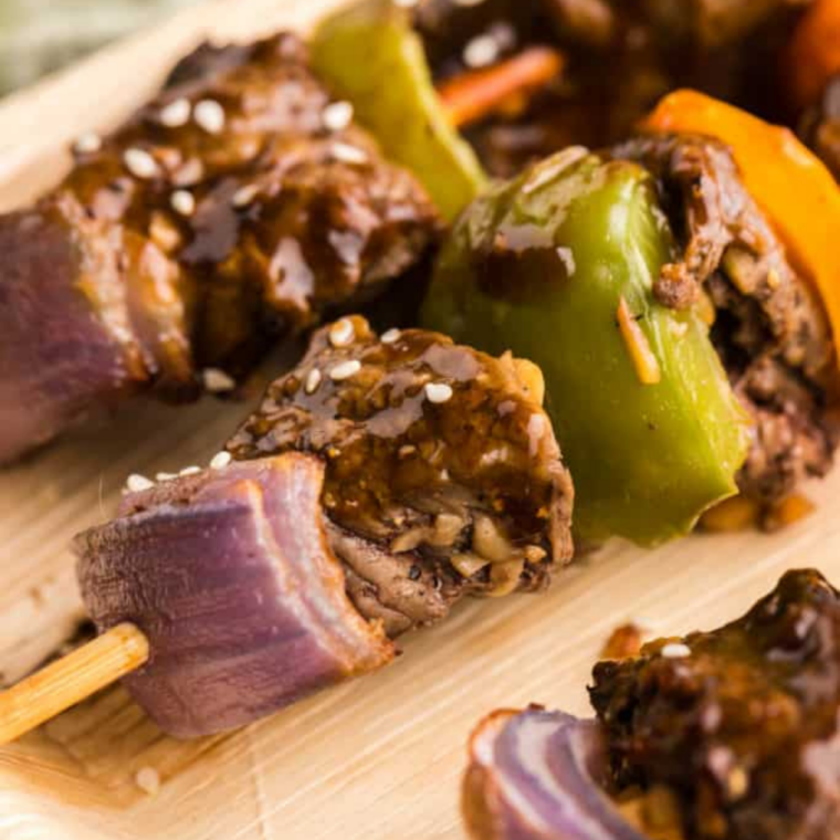 Steak skewers on Blackstone griddle with charred beef and vegetables
