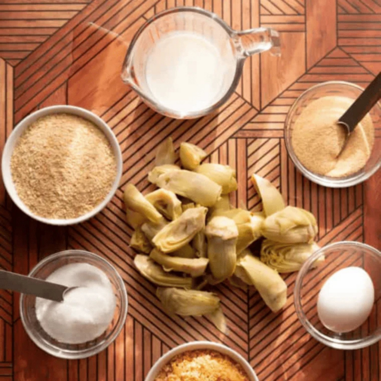 Labeled ingredients for air fryer artichoke hearts including artichokes, egg, milk, panko, and seasonings