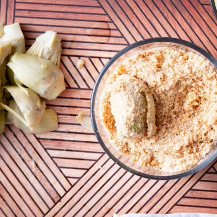Breaded artichoke hearts arranged in a single layer in the air fryer basket
