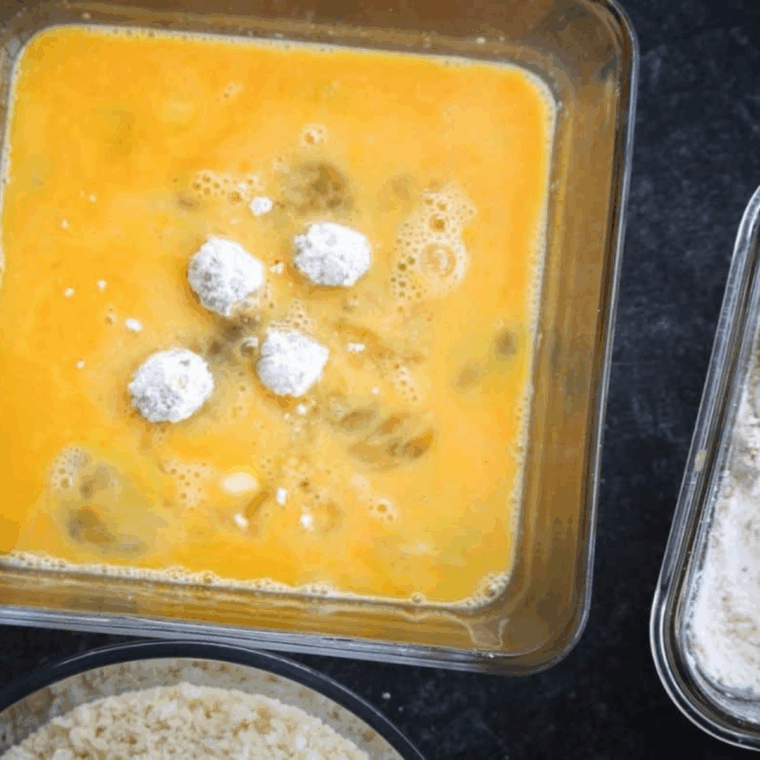 Olives being drained, dried, and coated in flour, egg, and Panko breadcrumbs, ready for air frying.