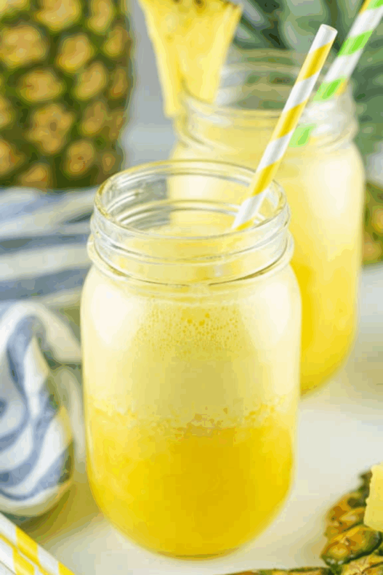 Frozen Ninja Creami pineapple agua fresca served in a glass with ice and fresh pineapple garnish