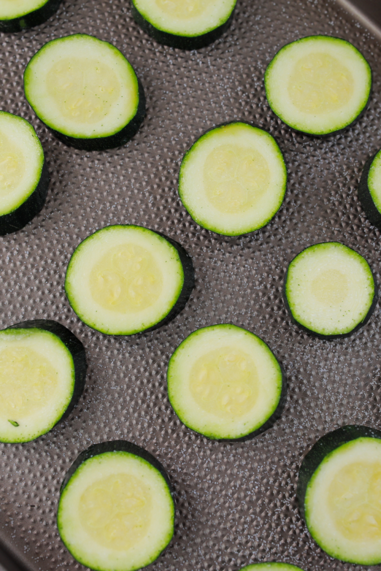 Zucchini planks salted and resting on towel to release moisture