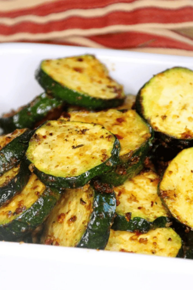 Close up of Ninja Foodi grilled zucchini slices with deep grill marks and herbs