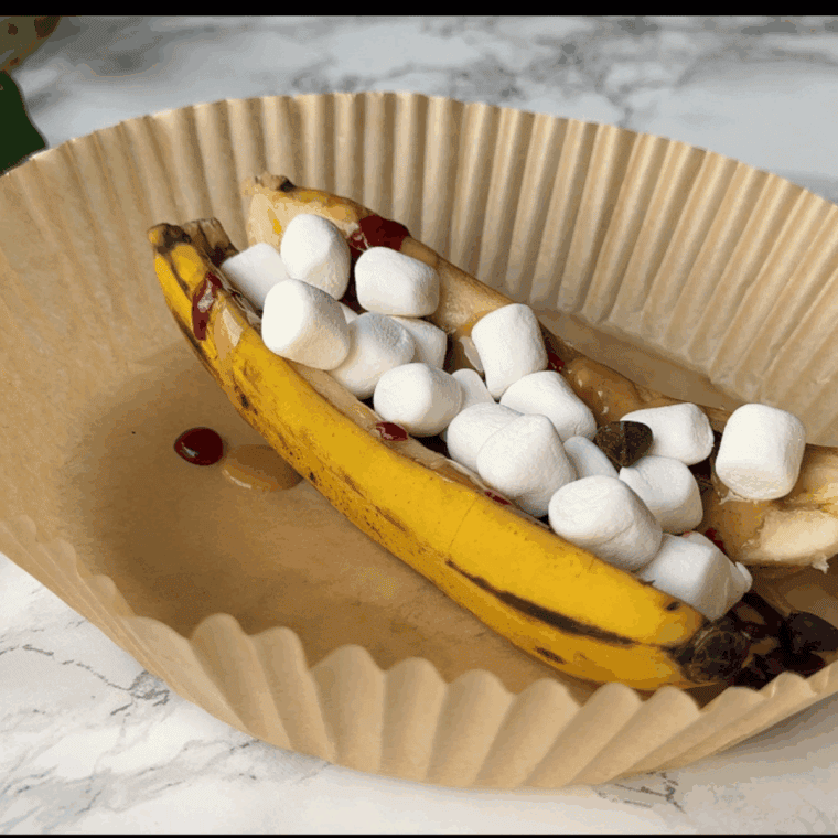 Air fryer banana split with warm bananas, ice cream, and toppings