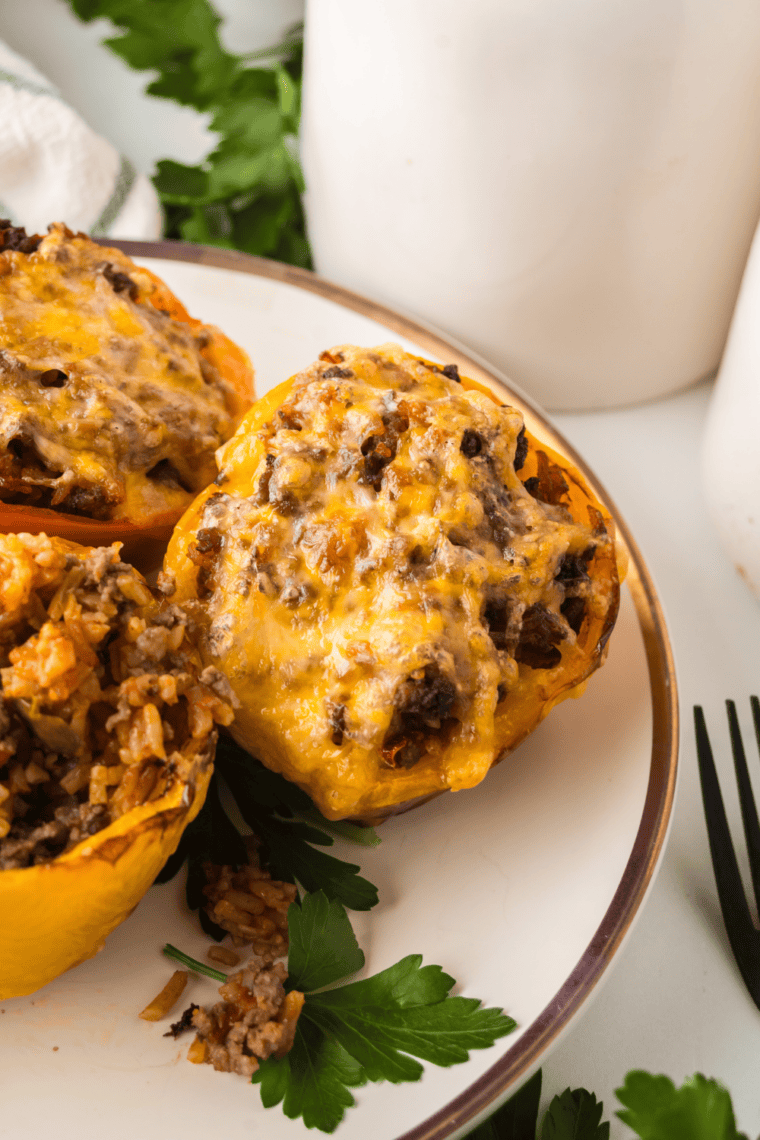 Four Cuban picadillo stuffed peppers in an air fryer basket, filled with ground beef, green olives, and raisins