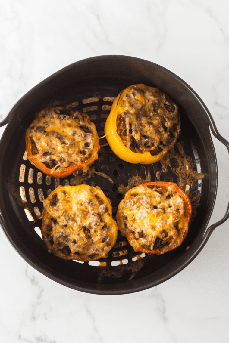 Air fryer picadillo stuffed peppers topped with melted cheese and fresh cilantro