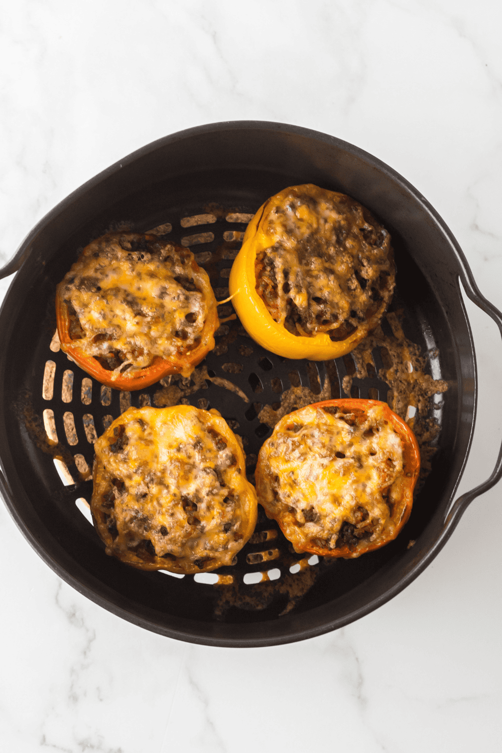 Air fryer picadillo stuffed peppers topped with melted cheese and fresh cilantro