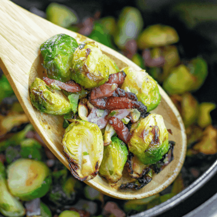 Air fryer-ready Brussels sprouts and bacon coated in olive oil and seasonings, ready to cook.