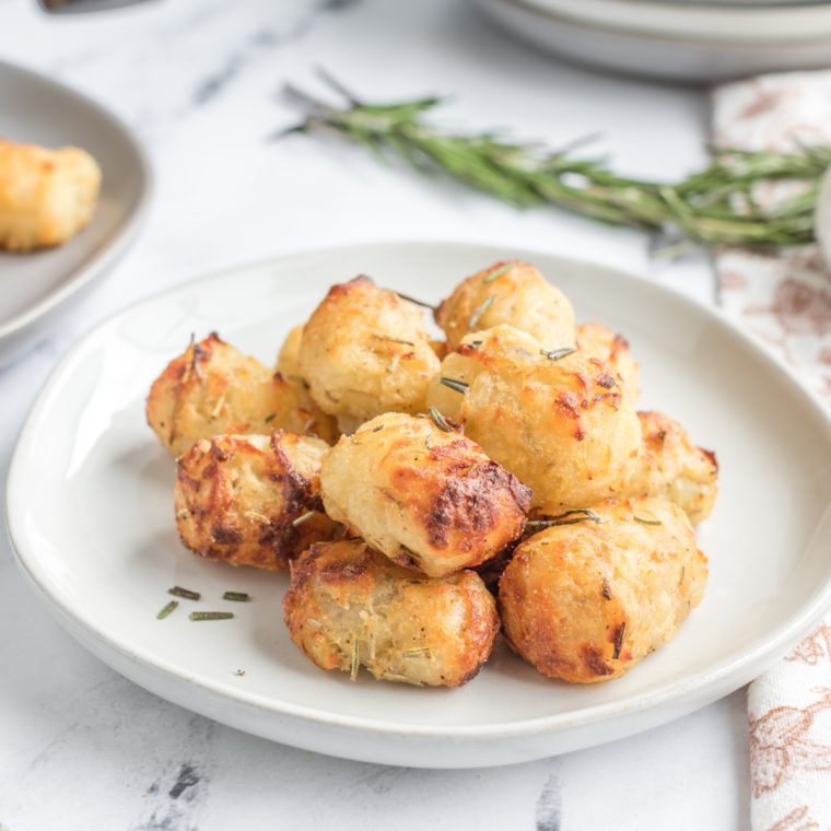 Topping crispy smashed potatoes with parmesan cheese and finishing until melted and browned.