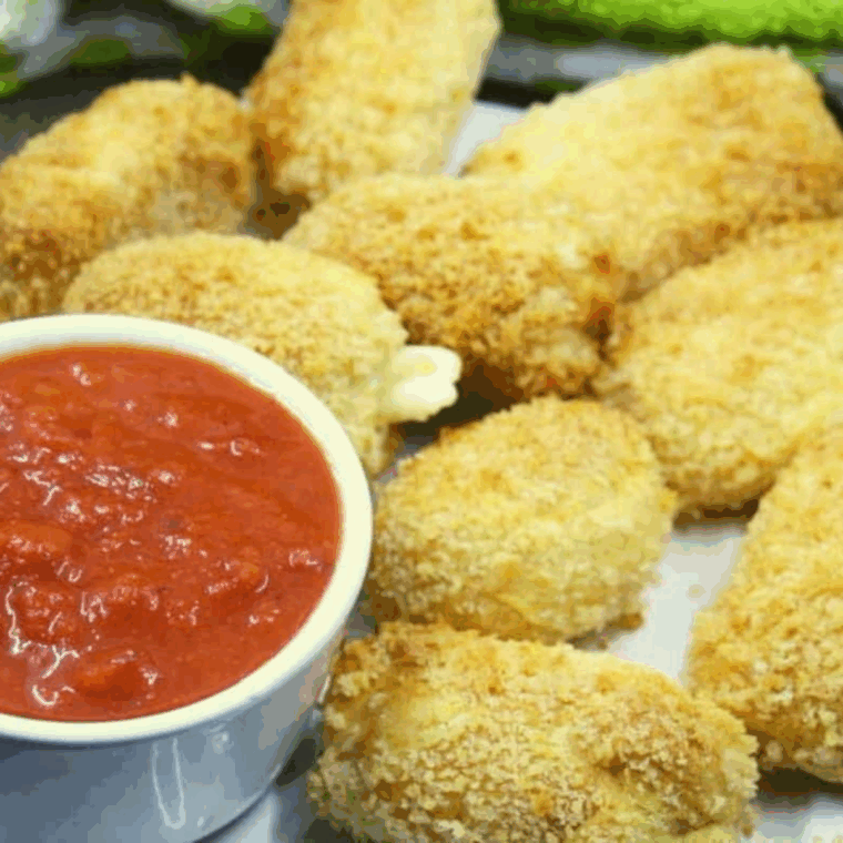 “Golden, crispy Air Fryer Brie Bites with melted cheese inside, served on a plate.”