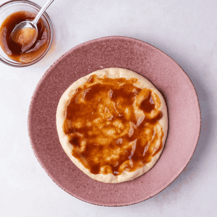 Brush tomato sauce over the pita bread.