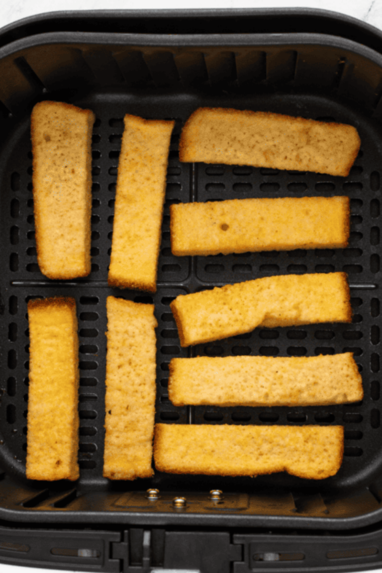 Arrange in the Air Fryer: Coated French toast sticks placed in a single layer in air fryer basket