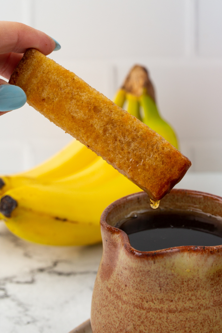 Serve with Toppings: Golden French toast sticks served warm with syrup, berries, and powdered sugar