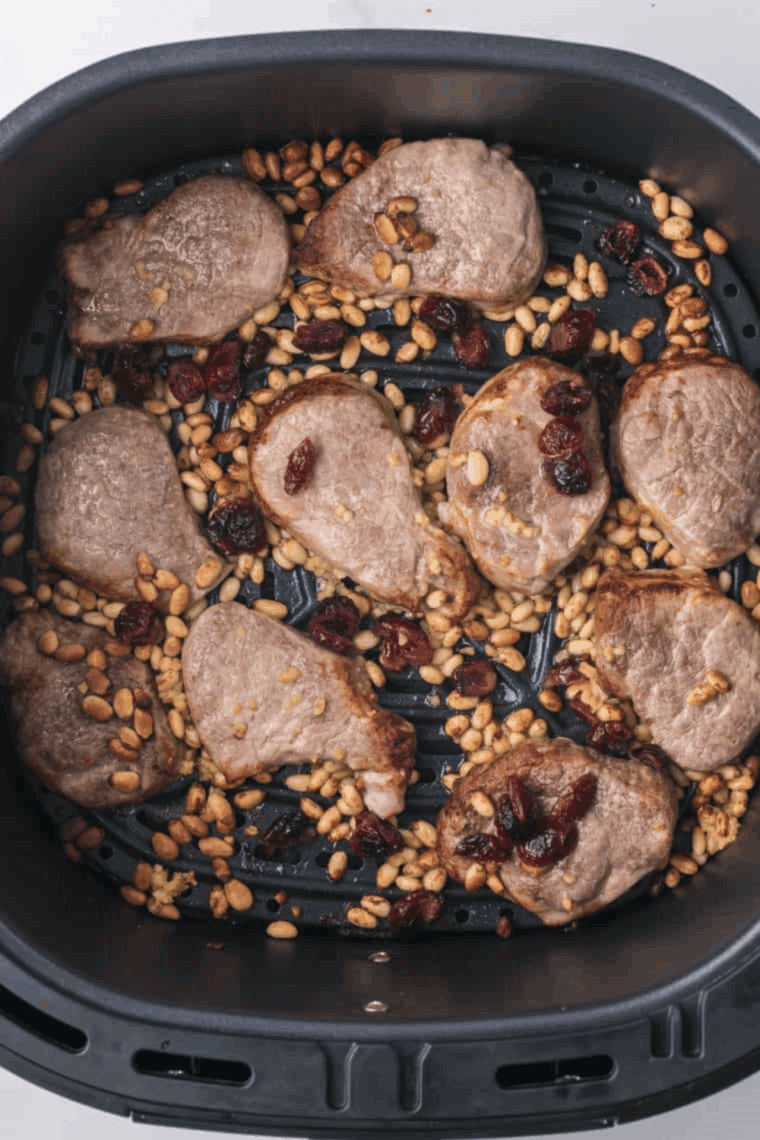 Cooked pork chop bites in the air fryer basket.