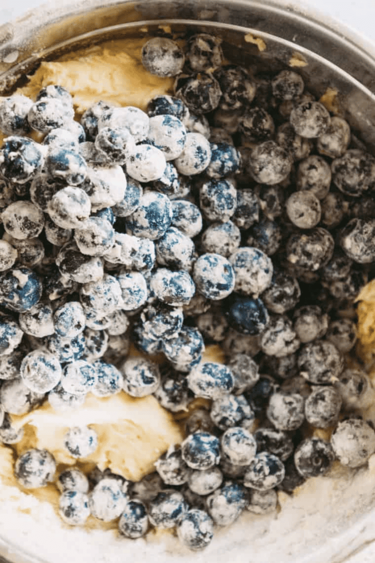 Rinsing blueberries, coating them lightly in flour, and folding them gently into muffin batter.