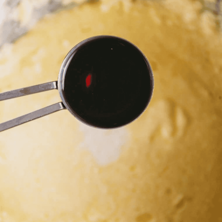 Gradually adding eggs, heavy cream, vanilla, and flour to create smooth muffin batter.