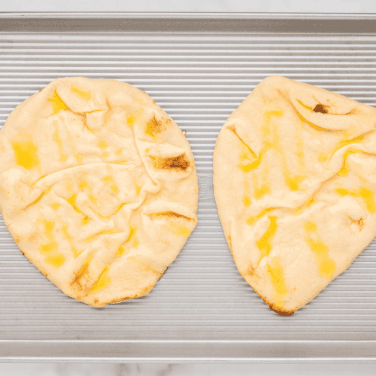 Flatbread on clean surface, drizzled with olive oil and garlic salt.