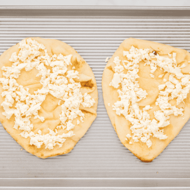 Spread cheese on top of the naan bread.