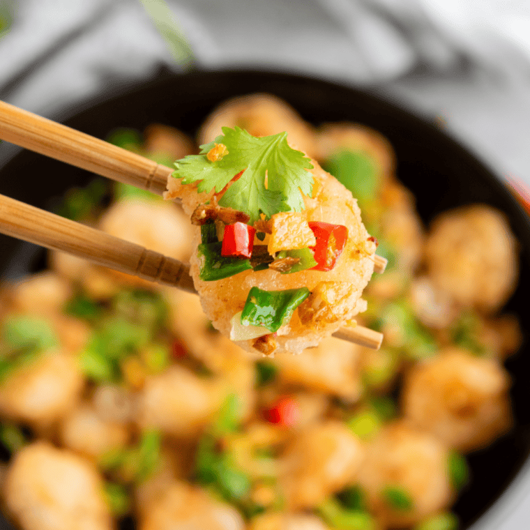 Crispy air fryer salt and pepper shrimp topped with fried garlic, red chili, and scallions.