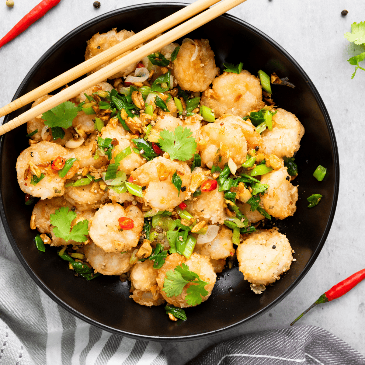Crispy air fryer shrimp tossed in a skillet with fried garlic, chili, and scallions
