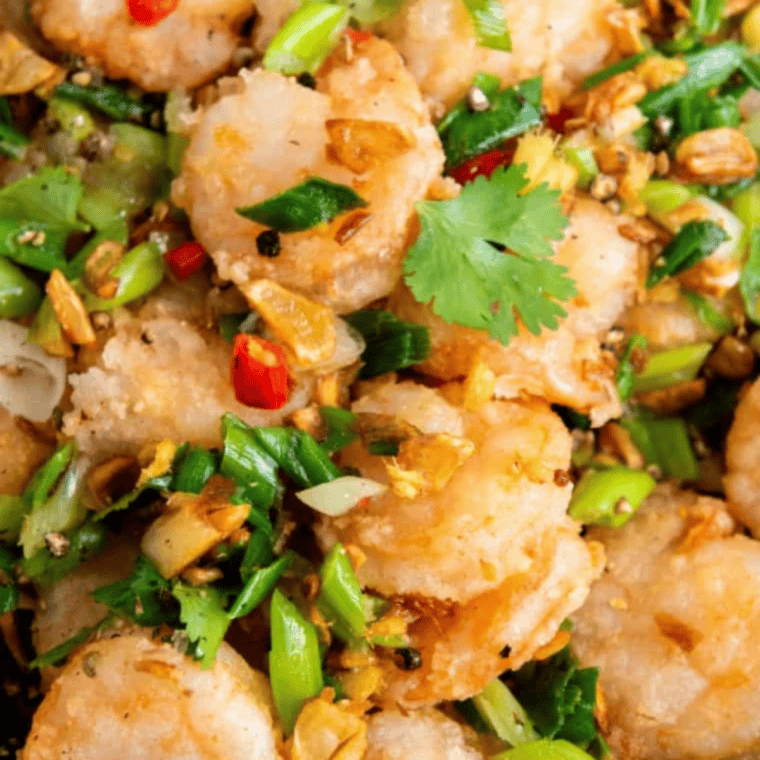 Shell-on close-up: Shell-on Chinese salt and pepper shrimp air fried until golden and crispy with garlic chips and sliced chilies