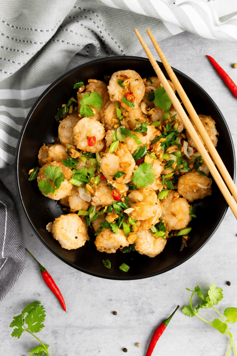 Air fryer salt and pepper shrimp served over steamed jasmine rice with scallions and lime wedges