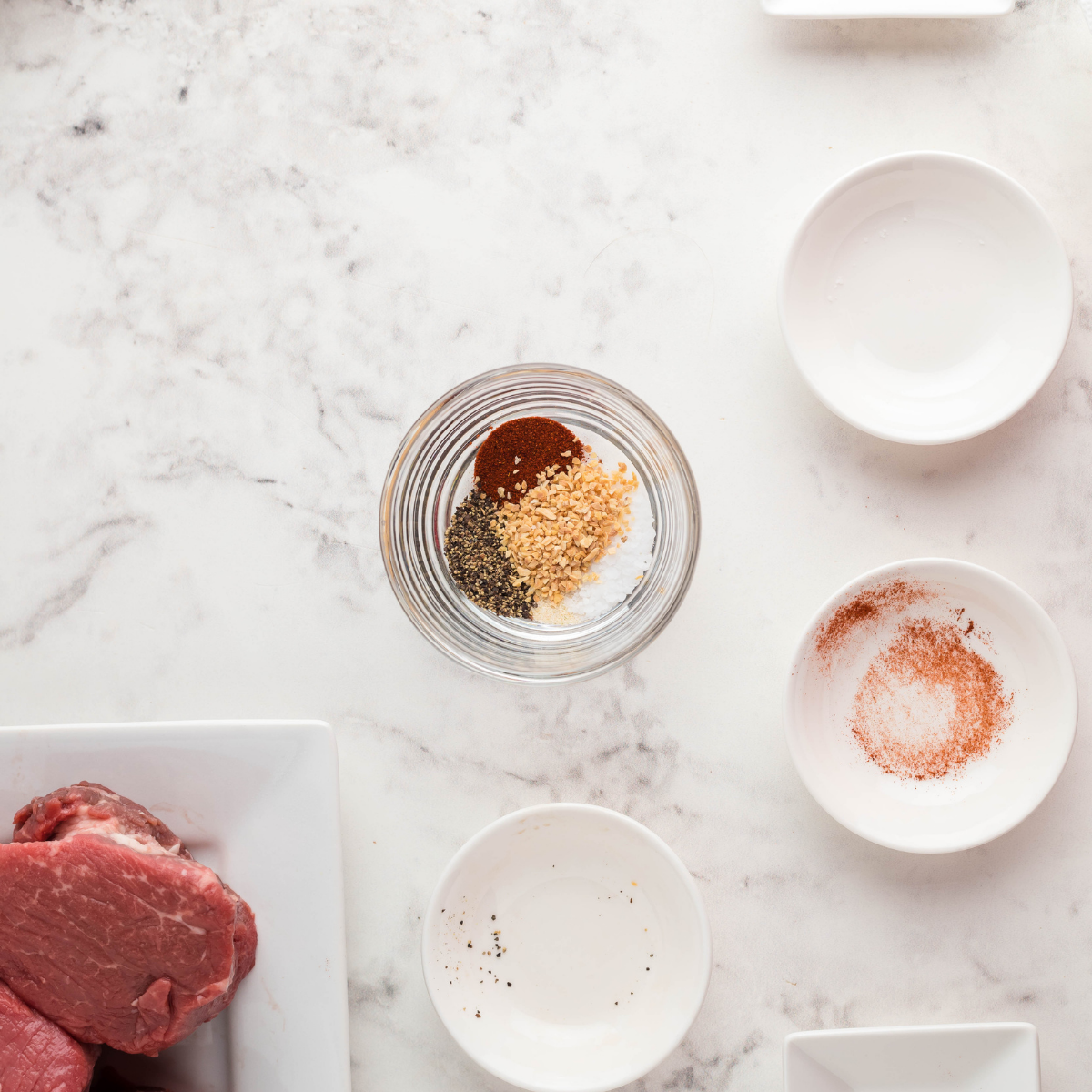 Filet mignon steaks resting at room temperature after being removed from the fridge before cooking.