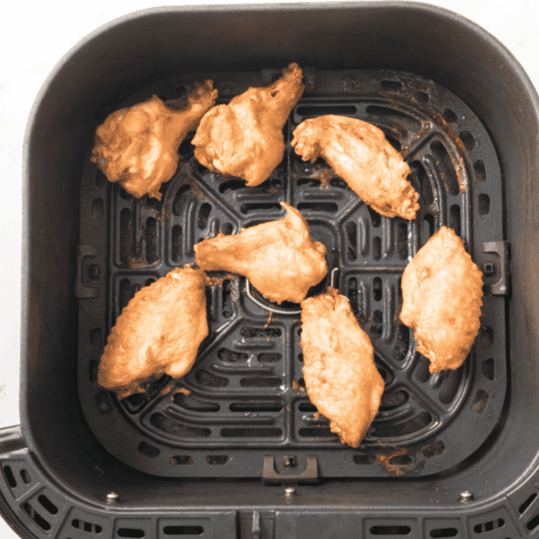 Crispy wings tossed in spicy garlic sauce in large bowl