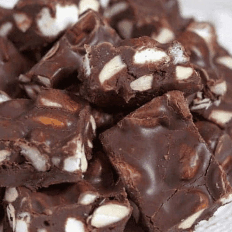 Stack of thick copycat Buc-ee's rocky road fudge squares with mini marshmallows and toasted pecans