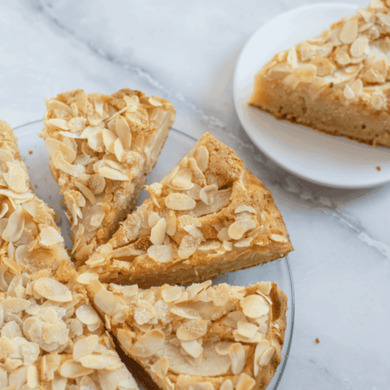 Easy air fryer almond cake with golden top and almond garnish on a serving plate.