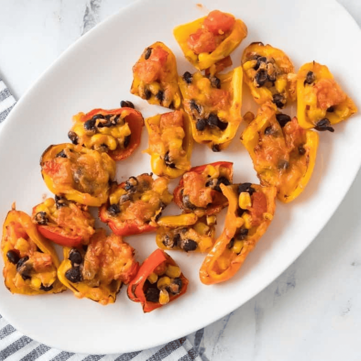Air fryer stuffed mini peppers with melted cheese, colorful and garnished with fresh herbs