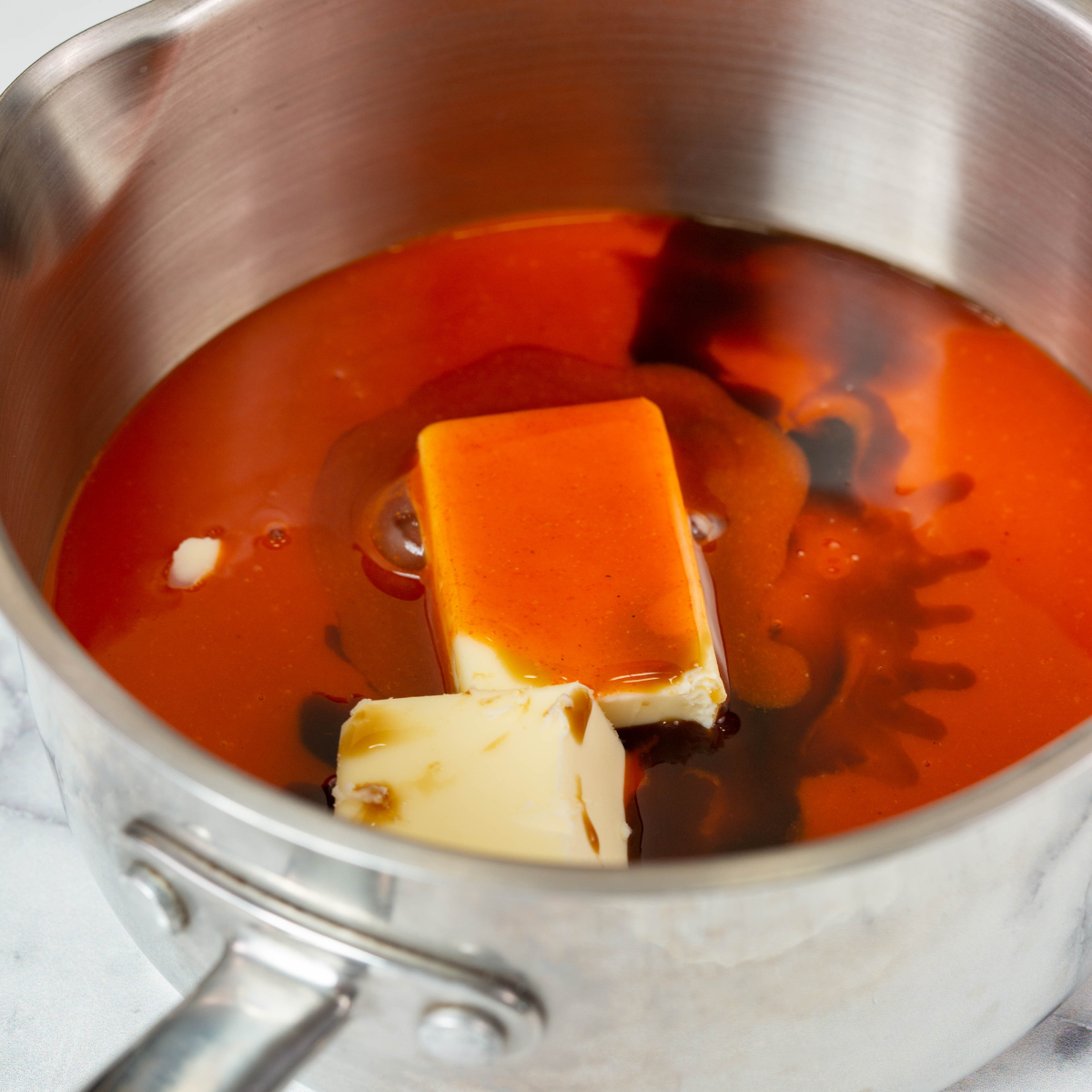 Melting butter and mixing with buffalo sauce in a small bowl.