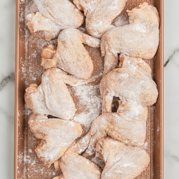 Coating chicken wings in a mixture of baking powder, salt, pepper, garlic powder, and paprika.