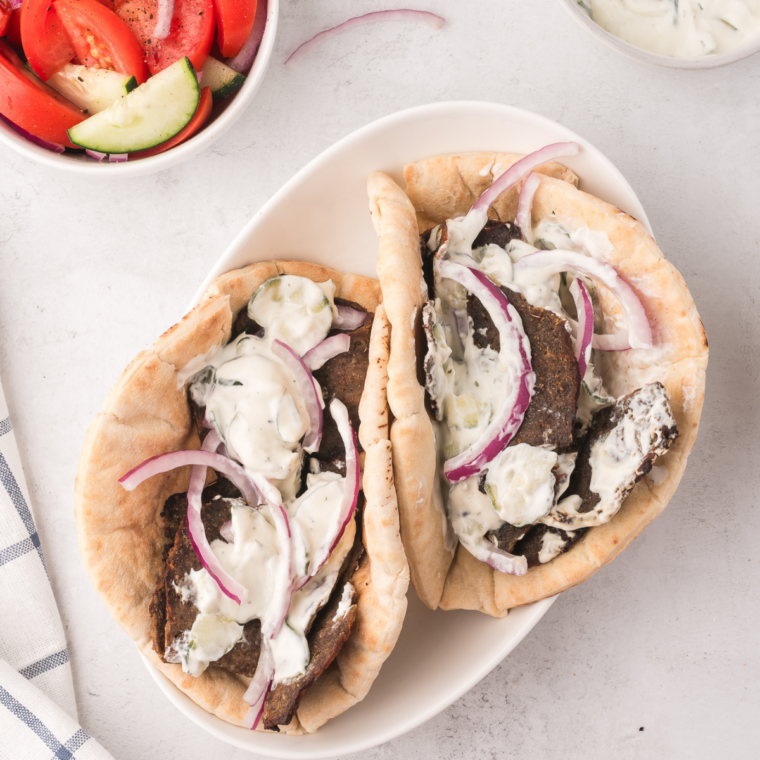 Fork lifting a Trader Joe's gyro slice with a crisp browned edge above a plate of air fried slices