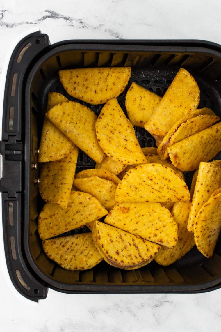 Frozen mini chicken tacos being separated from package before air frying