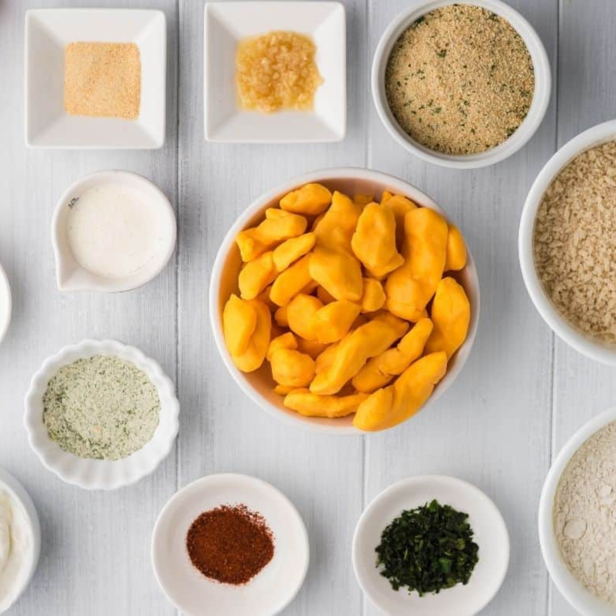 Cheese curds, flour, eggs, milk, and panko breadcrumbs in bowls for air fryer cheese curds
