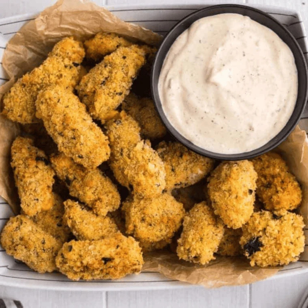 Breaded cheese curds in an air fryer basket after cooking until golden