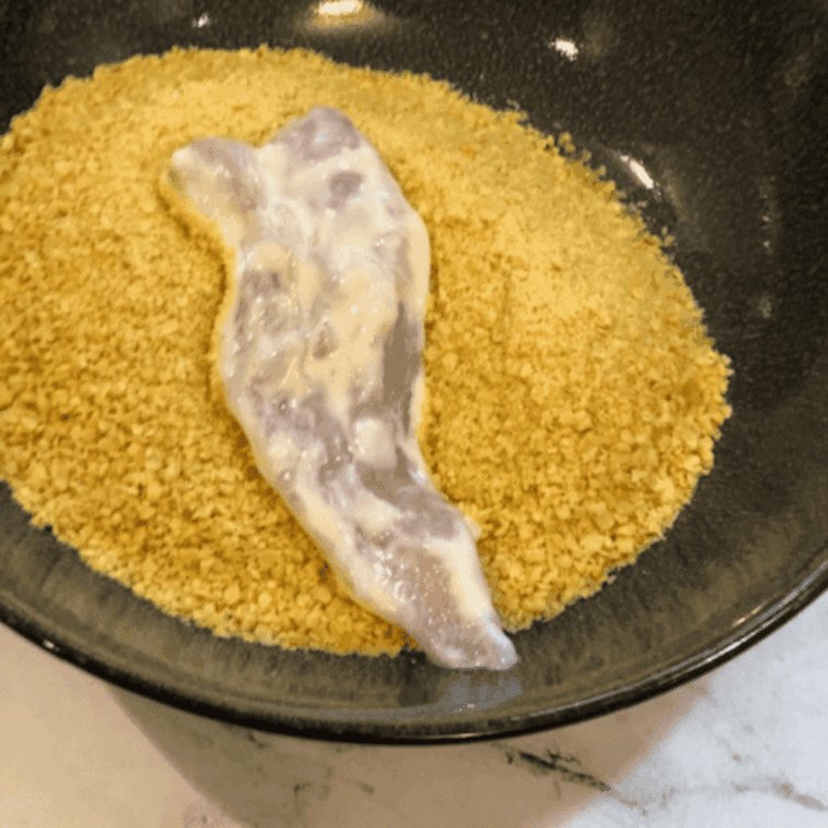 Dredging seasoned chicken tenders in a flour and Cajun spice mixture to create a craggy crust.