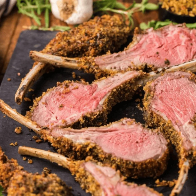 Air fryer lamb cutlets drizzled with lemon juice and garnished with fresh herbs