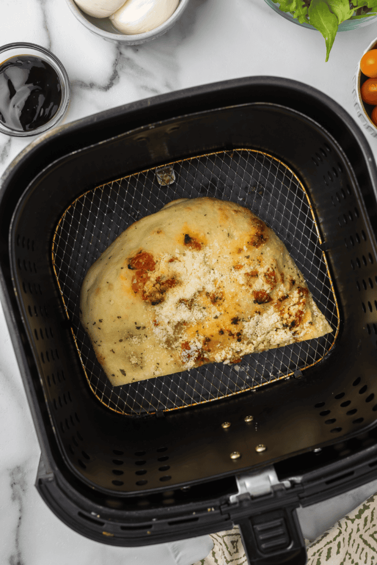 Focaccia bread placed in air fryer basket preheated to 400 degrees for crisping