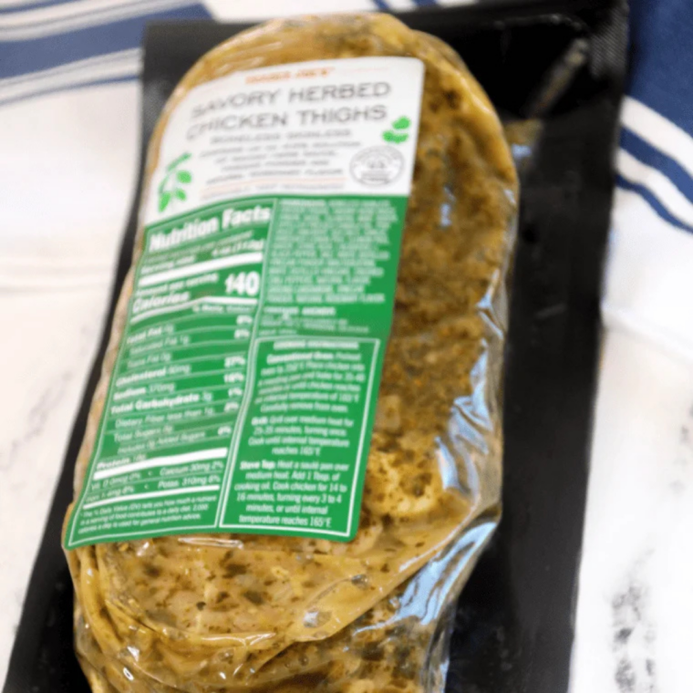 Package of Trader Joe's Savory Herbed Chicken Thighs next to cooking spray, ready for the air fryer