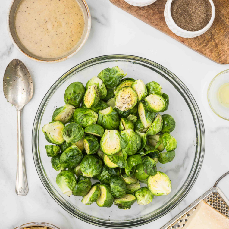 Prep the sprouts: Fresh Brussels sprouts trimmed, cleaned, halved, and patted dry on a cutting board before cooking.