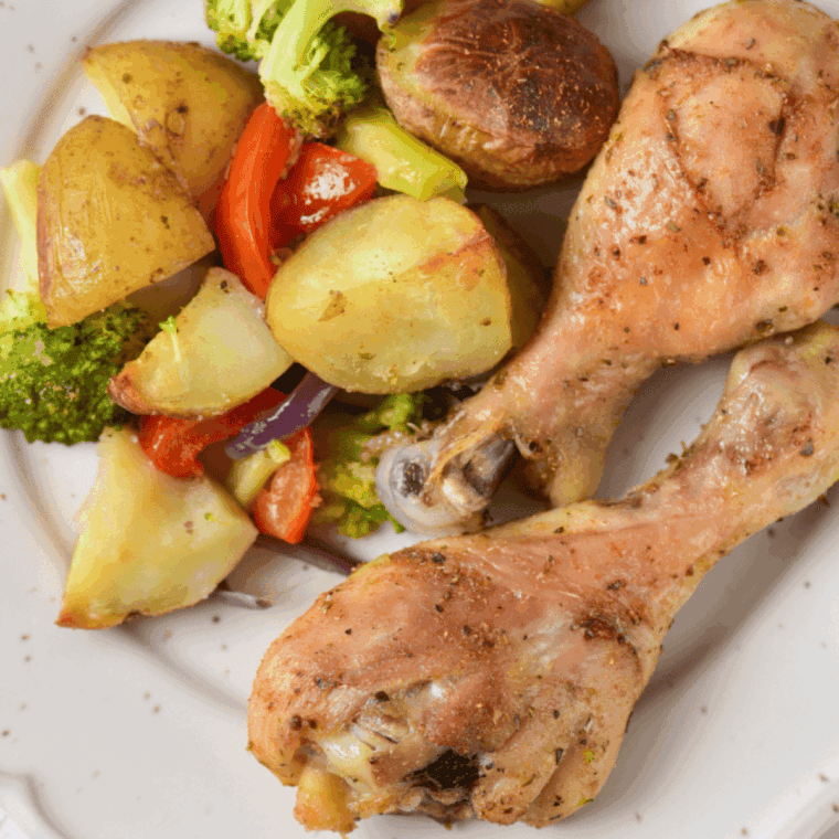 Plate of Juicy air fryer chicken drumsticks paired with crisp-tender vegetables.