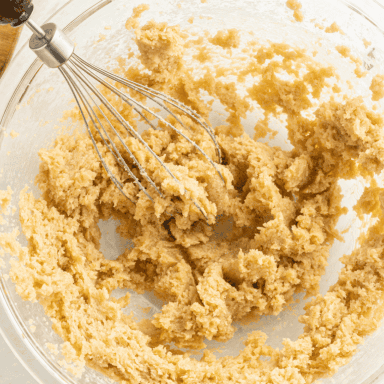 Folding crushed chai tea leaves into cookie dough evenly.