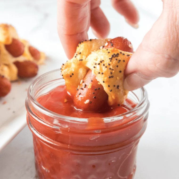 Air fryer bagel dogs on a white plate served with mustard and ketchup