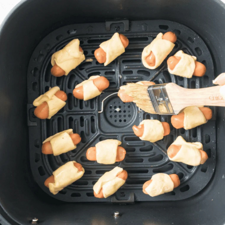 Air fryer bagel dogs arranged in a single layer in the air fryer basket